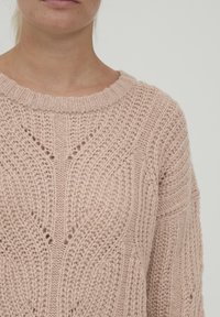 Pull rosa lavorato a maglia con scollo rotondo, motivo testurizzato, dettagli di cucitura aperta e polsini e orlo a costine.