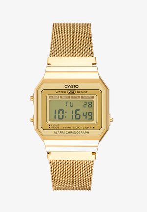 Zlaté digitální hodinky s osmiúhelníkovým ciferníkem, pletacím řemínkem a LCD displejem. Obsahují tlačítka pro alarm a chronografické funkce. Vodotěsné.
