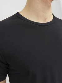Schwarzes Baumwoll-T-Shirt mit Rundhalsausschnitt. Der Stoff wirkt glatt und leicht, mit kurzen Ärmeln und minimalen Nähdetails.