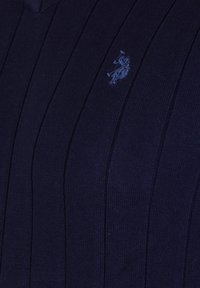 Navy gebreide trui met verticale ribbeltextuur, V-hals ontwerp en een klein geborduurd logo op de linkerborst.