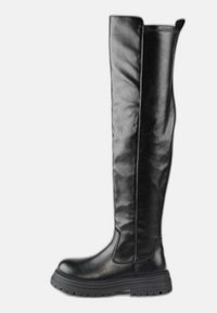Bota alta de cuero negro con suela gruesa de goma, puntera redonda y lengüeta en la parte superior, mostrada de perfil sobre fondo blanco.