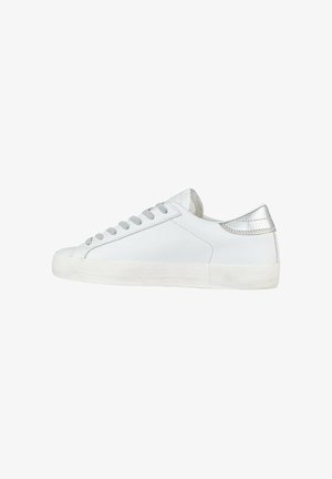 Zapatillas de cuero blancas con una textura suave, punta redondeada, cordones gris claro y un detalle plateado en el talón. Suela de goma con un ligero envejecimiento.