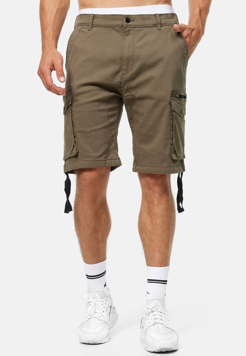 Shorts cargo vert olive en tissu durable, avec poches latérales, liens ajustables à l'ourlet et fermeture à bouton.
