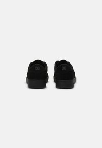 Zapatillas de skate de ante negro con un acabado texturizado, diseño bajo y acento con el logotipo en el talón. Suelas de goma lisas que ofrecen agarre.