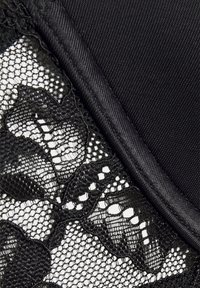 Lingerie preta com delicada renda floral sobre um tecido suave, com bordas suaves e um detalhe texturizado em contraste.