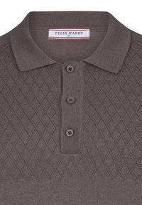 Polo de punto marrón con un patrón de diamantes, cierre de tres botones y etiqueta de cuello acanalado con "FELIX HARDY" en azul y rojo.