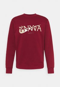 Sweat-shirt à manches longues bordeaux à col rond avec inscription beige "YNWA" et logo Nike swoosh, petit texte "Liverpool FC" en beige sous le centre.