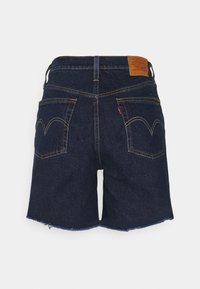Mörkblå denimshorts med fransad kant, med bakfickor som har en klassisk rund sömdesign och en läderlogg på midjebandet.