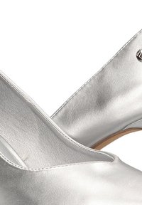 Zapatos de tacón alto plateados hechos de cuero metálico elegante, con una textura suave, punta redondeada y un diseño de corte sutil.