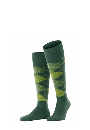 Par de calcetines verdes hasta la rodilla con patrones de rombos de argyle en tonos verde más oscuros y más claros y pequeñas líneas beige sobre un fondo blanco.
