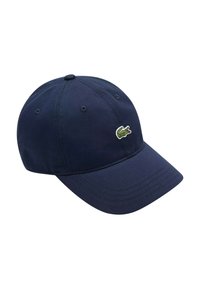 Cappellino da baseball blu navy in tessuto con visiera curva, con un piccolo logo di coccodrillo verde sul davanti. Design e texture classici.