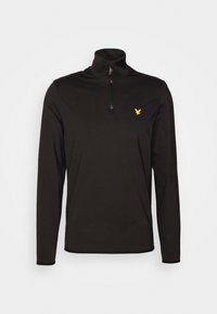 Zwarte pullover met lange mouwen, hoge kraag, halve rits aan de voorkant en een klein geel adelaarslogo op de linkerborst. Zacht materiaal, getailleerd ontwerp.