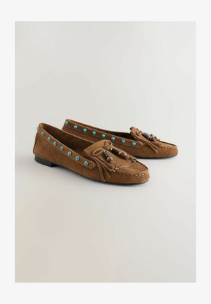 Pruunid seemisnahast mokassiinid madala kannaga, kaunistatud siniste naelte ja dekoratiivse hõlpsuga, millel on puidust helmeste aktsendid.