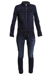 Combinaison en denim bleu foncé à manches longues, fermeture éclair devant, poches poitrine, taille à cordon et détails délavés sur les jambes.