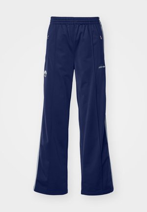 Pantaloni da atletica navy con cintura elastica, tasche laterali con zip e dettagli in argento. Presentano un logo sulla coscia e gambe larghe.