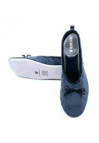 Ballerines bleu marine en daim doux, avec un bout rond, une finition élastique et un nœud décoratif à l'avant. Semelle blanche.