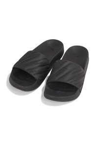 Sorte slides med en struktureret gummioverdel, der har en bred strop og mønstrede detaljer. Flad sål for nem brug og komfort.