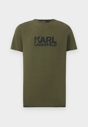 Olívazöld pamut póló rövid ujjakkal, kerek nyakkal, és a mellkason egy nagy fekete "KARL LAGERFELD" felirattal.