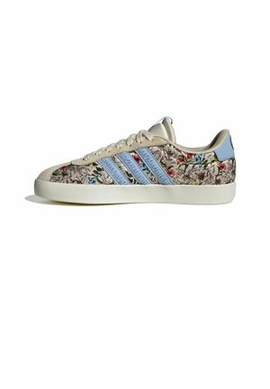 Sneaker beige con stampa floreale, strisce Adidas azzurro chiaro, linguetta del tallone abbinata azzurra, suola bianca e lacci beige su sfondo bianco.