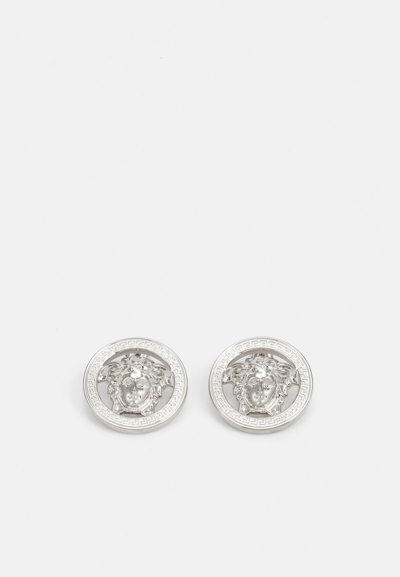 Boucles d'oreilles en argent avec un design complexe de tête de Méduse entouré d'une bordure circulaire à motifs. Texture lisse avec finition polie.