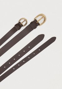 Brun læderbælte med en guldfarvet spænde. Har tre længder, huller til justering og en glat, mat finish.