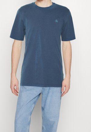 Granatowy t-shirt z krótkim rękawem, wykonany z bawełny. Posiada okrągły dekolt, minimalistyczny design oraz małe turkusowe logo na lewej piersi.