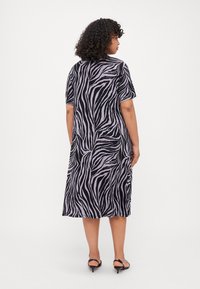 Rövid ujjú, térdzokni hosszad dressz, fekete és levendula csíkos zebra mintával. Puha anyagból készült, laza szabású, kerek nyakkivágással.