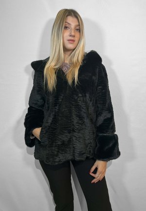 Giacca in pelliccia sintetica nera con un motivo testurizzato e ondulato, cappuccio grande e maniche con polsini. Dotata di tasche frontali e di una finitura morbida.
