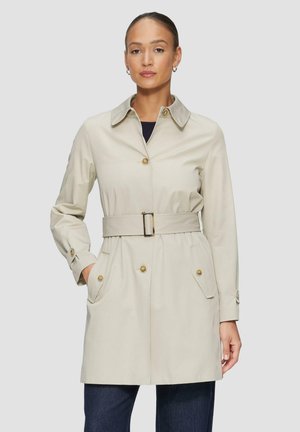 Trench coat beige con vita aderente, bottoni dorati, due tasche anteriori e colletto classico. Texture liscia, design fino al ginocchio.