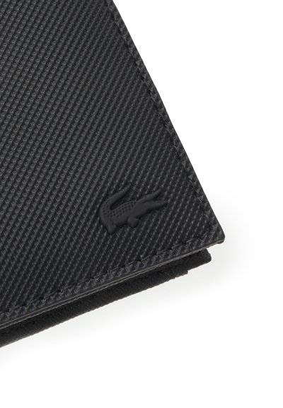 Portefeuille noir en cuir texturé avec un motif semblable à du carbone, présentant des bords cousus et un logo en relief subtil dans le coin.