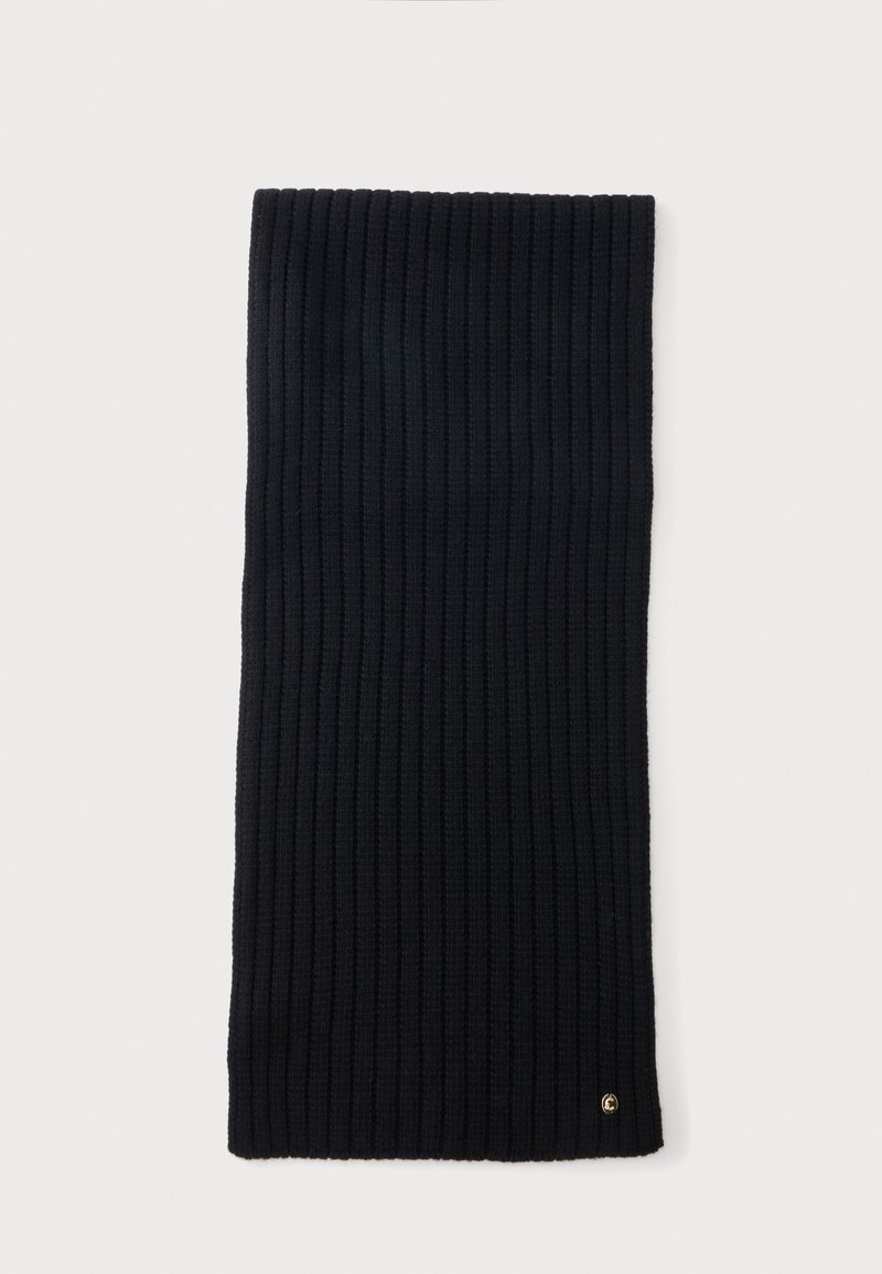 Écharpe en tricot côtelé noire, pliée à plat, avec un petit logo circulaire doré près d'un coin sur un fond clair.