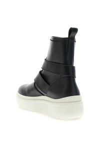 Botas de tobillo de cuero negro con un acabado liso, que presentan tres correas horizontales y una suela de goma blanca, ofreciendo un diseño elegante.