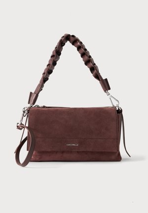 Sac à main rectangulaire en daim brun foncé avec poignée tressée, bandoulière amovible et détails de fermeture éclair argentés, nom de la marque centré sur le devant.