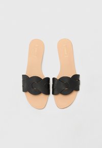 Zwarte slide-sandalen met een brede, verweven bandontwerp. Gladde leren bovenkant en een beige voetbed, met minimale branding op de binnenzool.