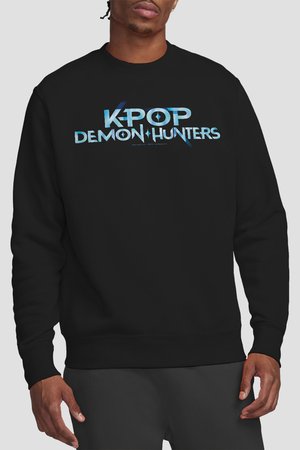 Mann trägt schwarzen Pullover mit blauem Schriftzug "K-POP DEMON HUNTERS" auf der Brust und steht vor einem einfarbigen Hintergrund.