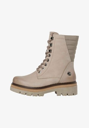 Lace-up ankle boot made of beige leather with ribbed accents, rounded toe, chunky tread sole, and decorative emblem on the side.