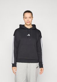 Moletom preto com logo branco da adidas no peito, riscas brancas nas laterais e um bolso frontal. Textura suave, ajuste relaxado e capuz com cordão.