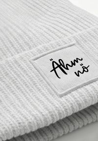 Light gray ribbed beanie with a soft texture and a square white patch displaying the text "Ähm nö" in black cursive font.