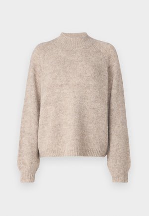 Pull en tricot beige avec un col montant, des poignets côtelés et une coupe décontractée, affichant une texture douce et de subtiles variations de couleur.