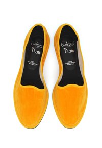 Scarpe slip-on in suede giallo con punta rotonda, rivestimento nero e tomaia texturizzata, con bordatura gialla a contrasto e suola piatta.