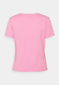 Lyhythihainen t-paita pehmeää vaaleanpunaista kangasta, pyöreällä pääntiellä ja suoralla leikkauksella. Selkäpuolella on hillittyjä ompeluominaisuuksia.