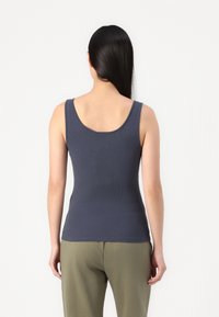 Marineblå ribbestrikket tanktop med scoop-halsing og brede skulderstropper; tettsittende design med glatt tekstur og minimal detaljer.