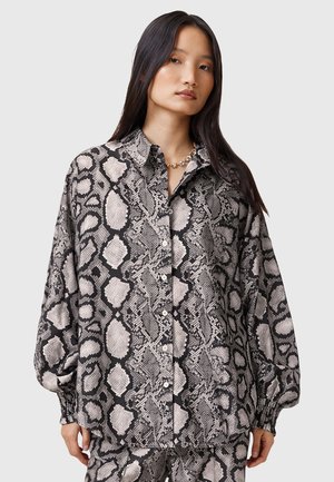 Blusa con stampa a serpente bianco e nero, design con bottoni, vestibilità rilassata, maniche lunghe e polsini elasticizzati, realizzata in tessuto leggero.