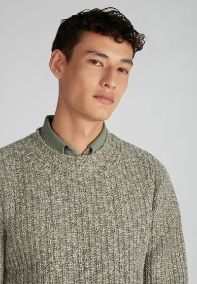 Strickpullover in hellem Oliv mit einem strukturierten, gerippten Muster und einem runden Halsausschnitt, darüber ein grünes Hemd mit Kragen.