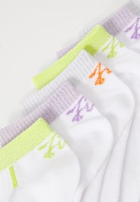 Chaussettes en coton blanches avec des bords côtelés de couleurs. Comprend des accents verts, violets et oranges avec des motifs de logo simples dans des couleurs assorties.