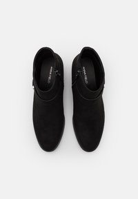 Botas de tobillo de ante negro con punta redonda, tacón bajo, cremallera lateral y un diseño liso y limpio. Presenta un logo en la plantilla.