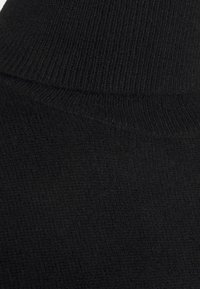 Sort strikket sweaterstof med et ribbet højhalset design, der har en blød tekstur og et ensartet mønster hele vejen igennem.