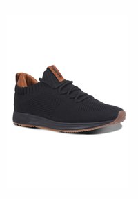Black knitted sneaker with a textured upper, brown leather accents at the collar and tongue, and a flexible rubber sole.
