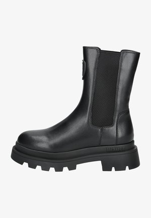 Bottine en cuir noir avec panneau latéral élastique, semelle crantée épaisse et languette à l’arrière, conçue pour un usage décontracté et robuste.