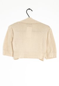 Cardigan cropped beige con mangas tres cuartos, textura acanalada y cuello en V. Cuelga de un gancho negro sobre un fondo blanco.